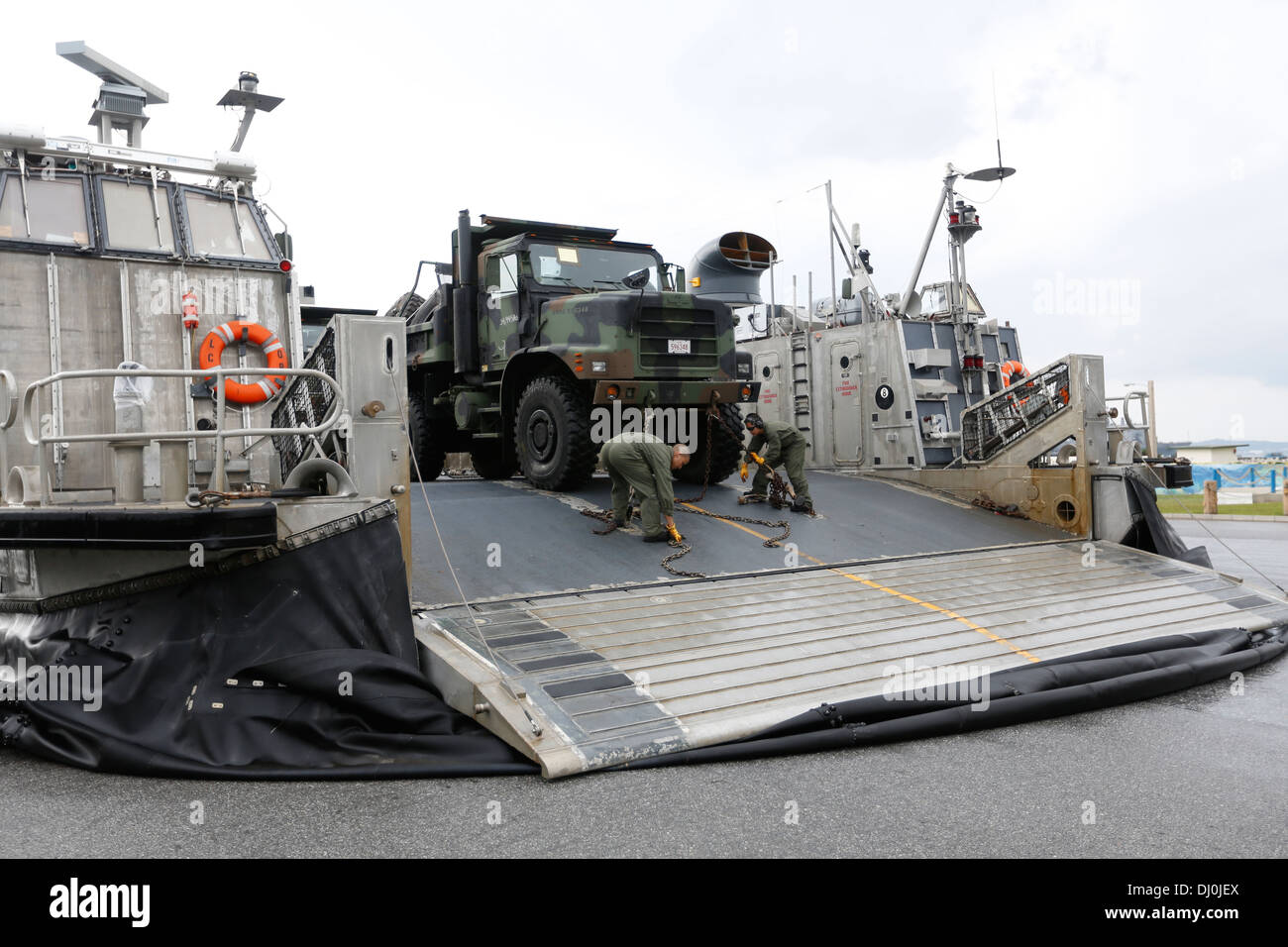 U.S. Sailors with the 31st Marine Expeditionary Unit, III Marine Expeditionary Force, chain down vehicles and equipment onto a Landing Craft Air Cushion at U.S. Navy White Beach Port Facility, Okinawa, Japan, Nov. 16, 2013. The Marines and Sailors loaded Stock Photo