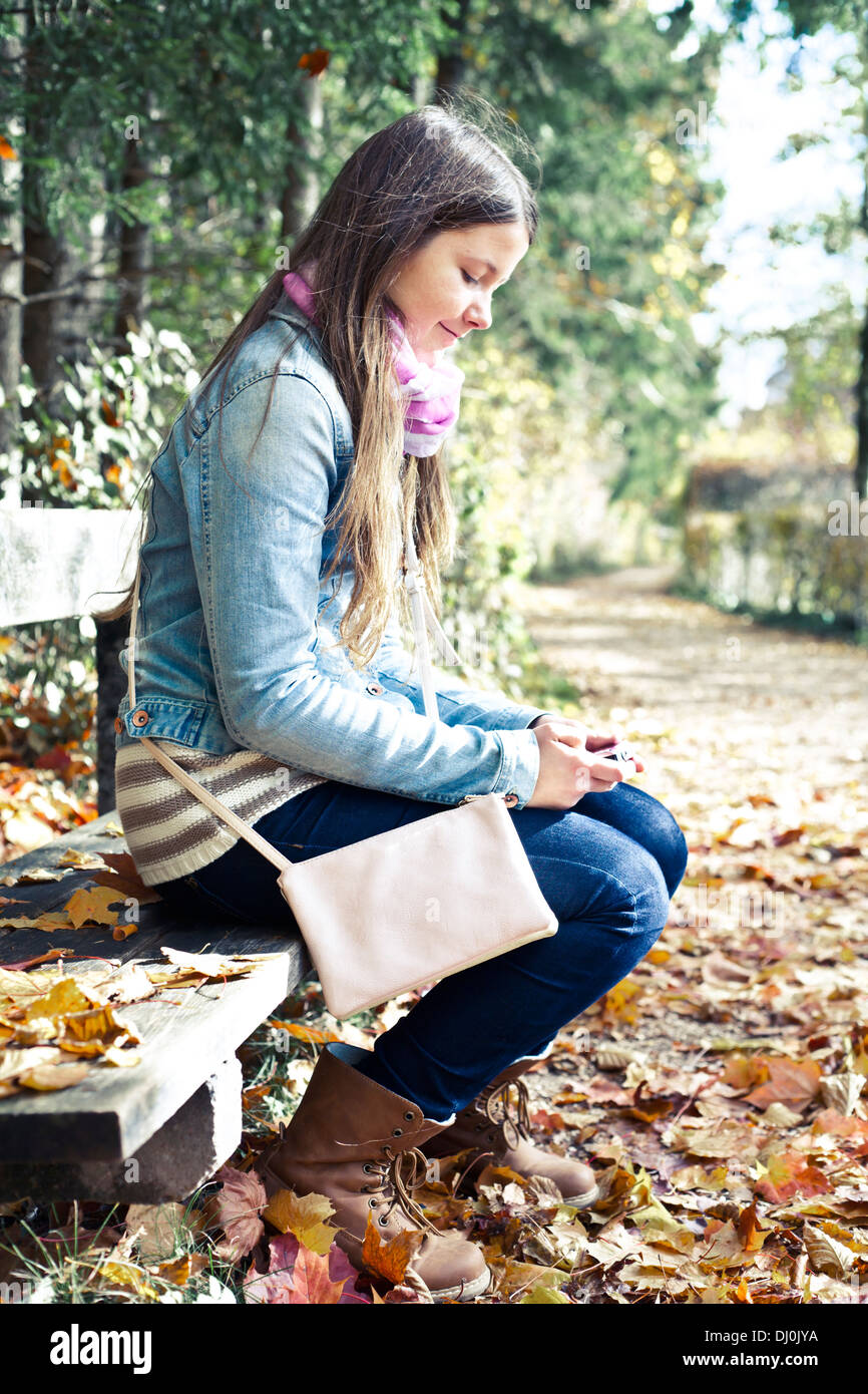 Girl sitting alone on bench hi-res stock photography and images - Alamy