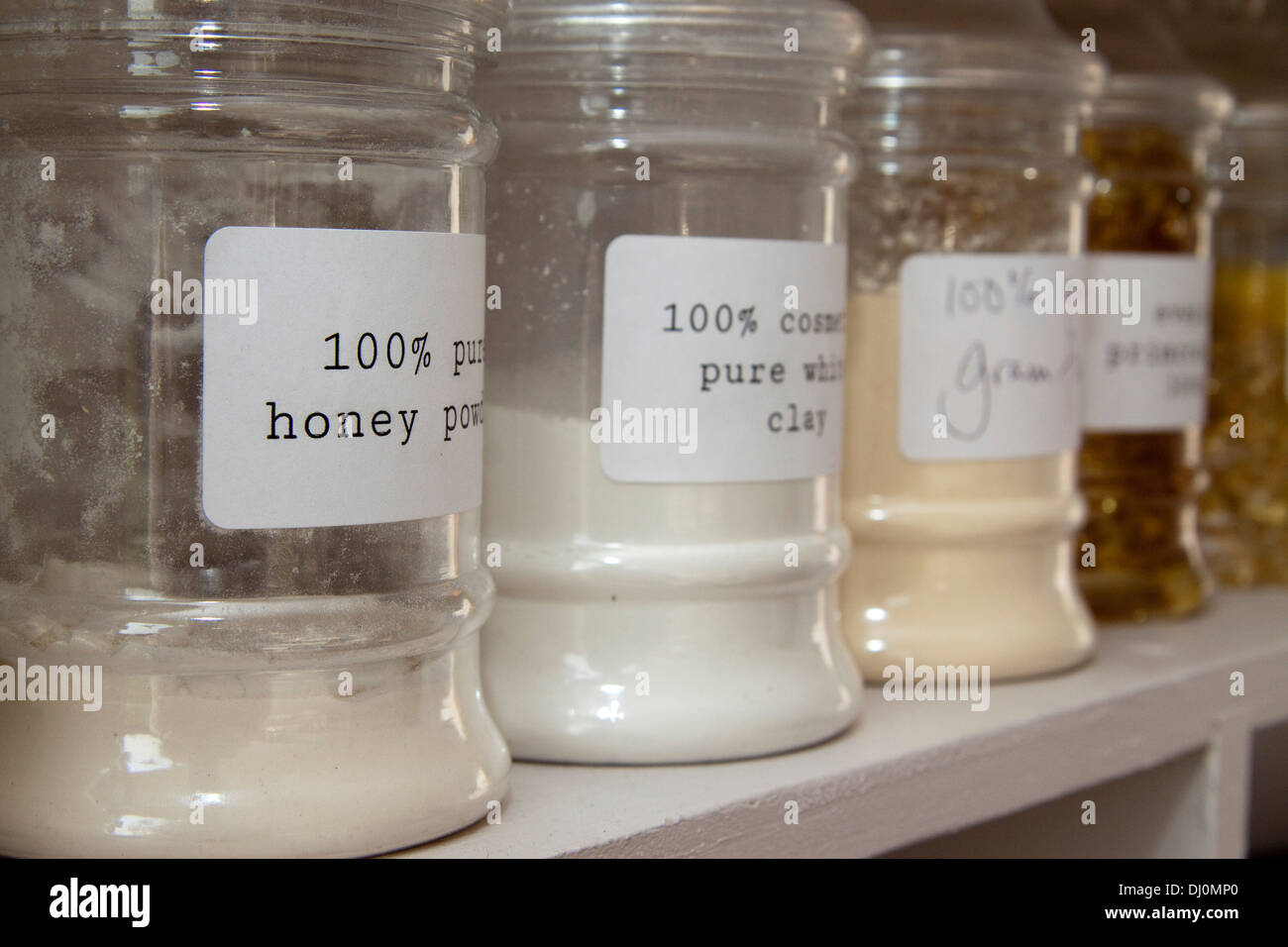 Labelled glass jars containing powders on a white shelf Stock Photo Alamy