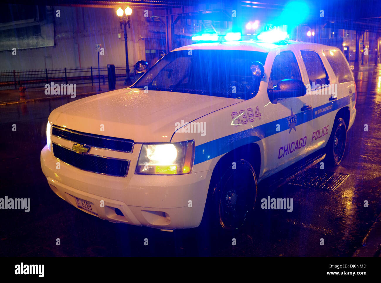 Chicago Police Chevrolet Chevy Tahoe (2006 - 2014) full size SUV 4x4 car with blue lights flashing in heavy early morning rain Stock Photo