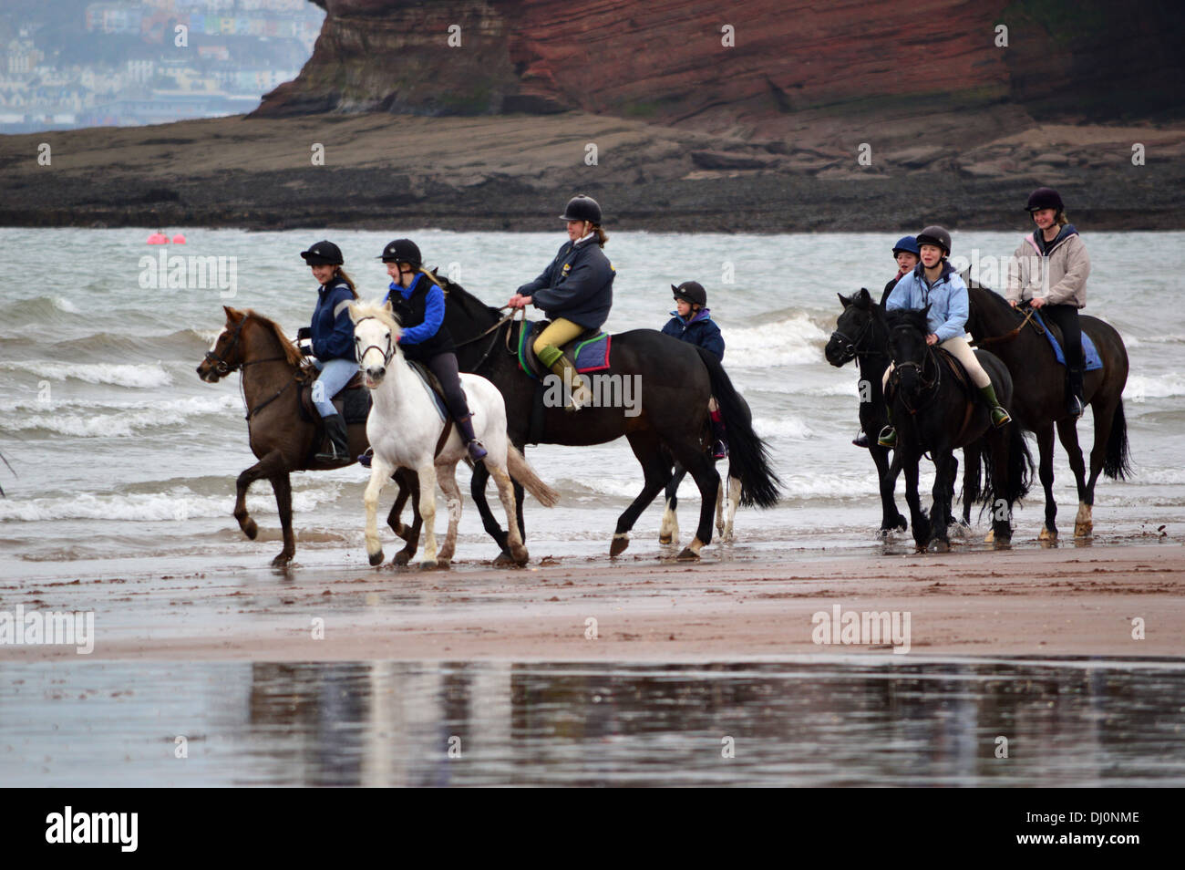 Group of horses and riders on beach at Paignton, Torbay, Devon, England, United Kingdom Stock Photo