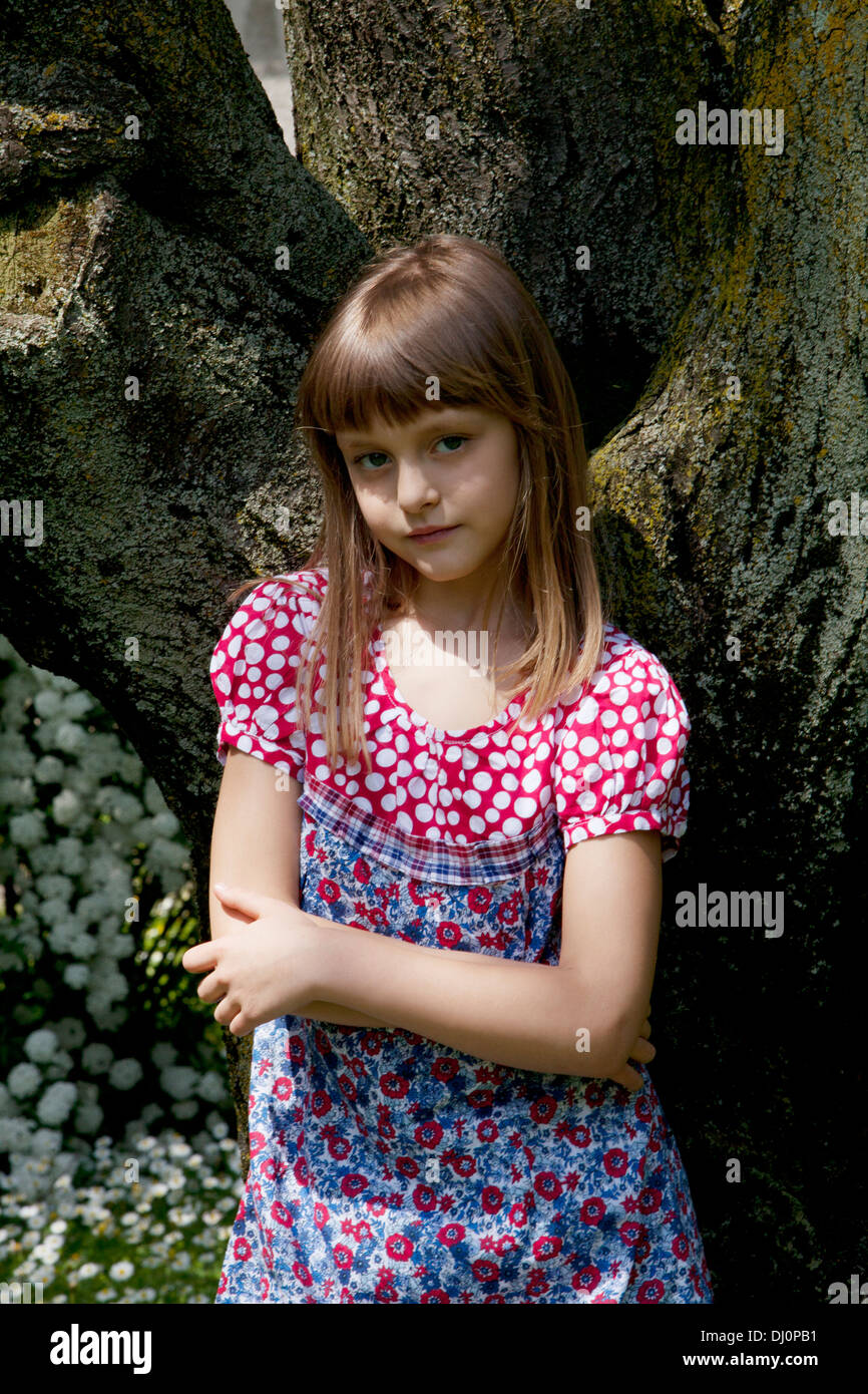 ams cherish Little girl leaning against tree hi-res stock photography and images - Alamy