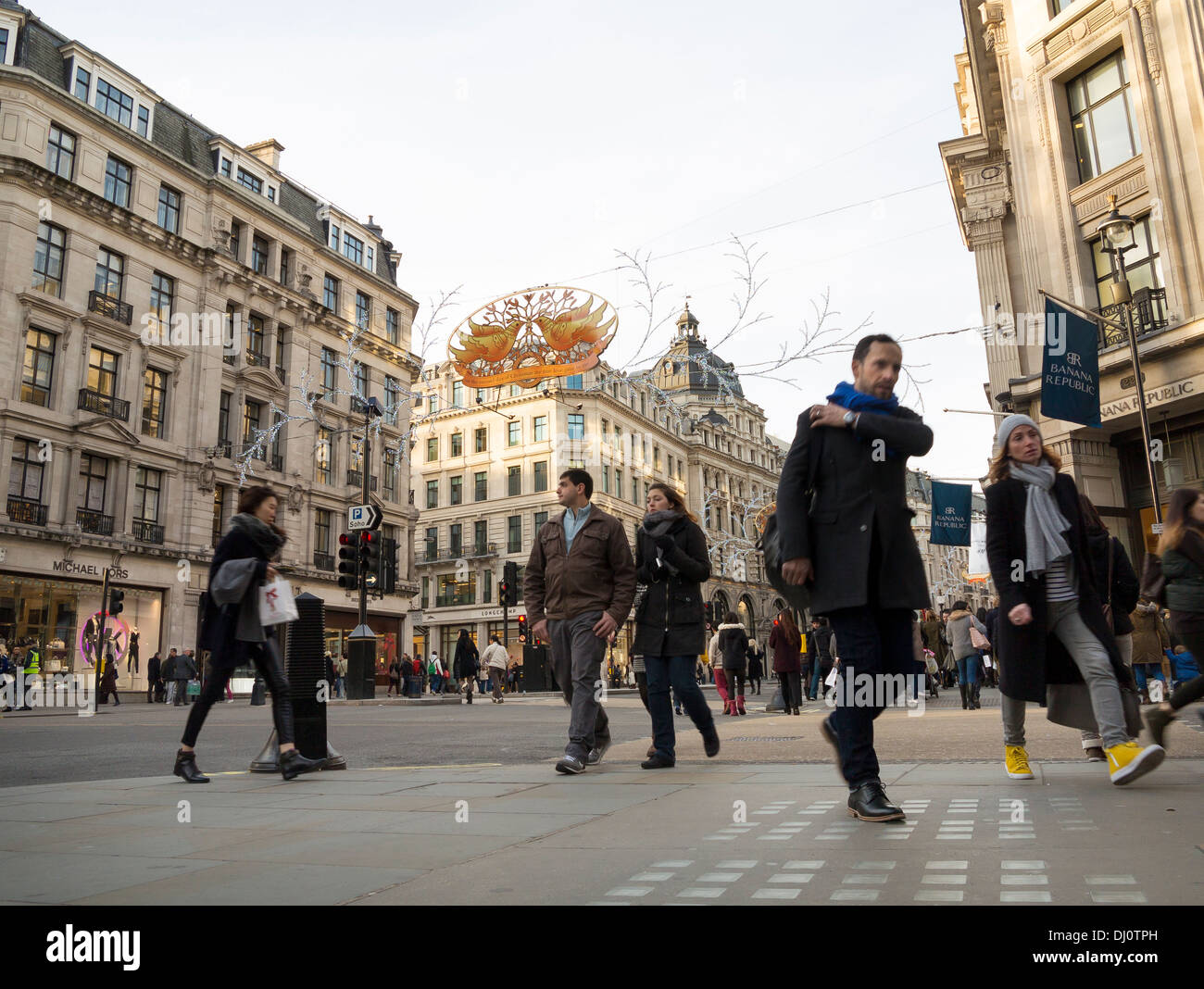 Christmas shoppers are on Regent Street beneath the Xmas decorations. Stock Photo