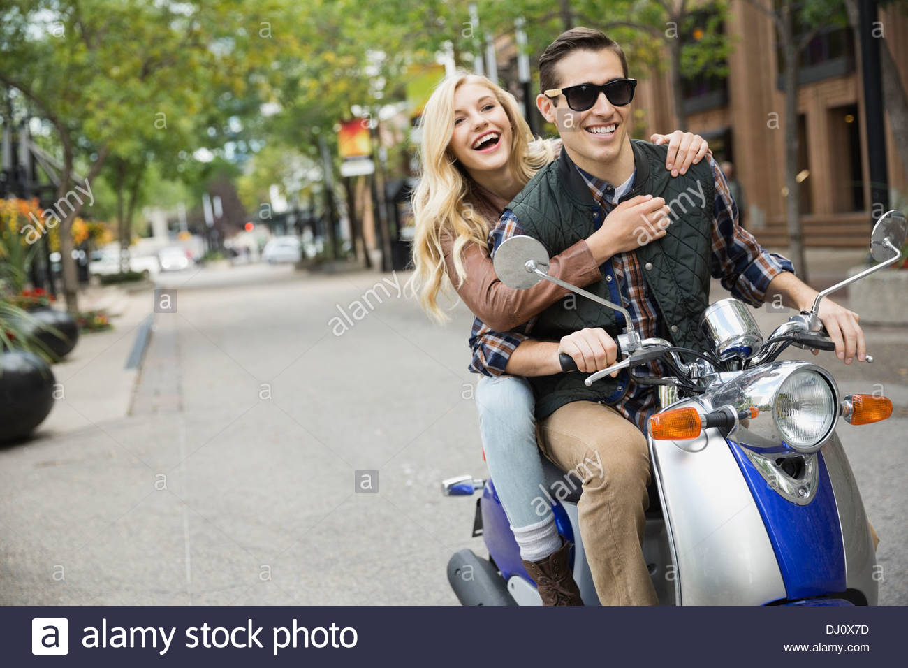 Couple riding on scooter Stock Photo