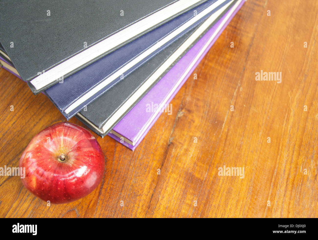red apple and old books on wooden table top Stock Photo