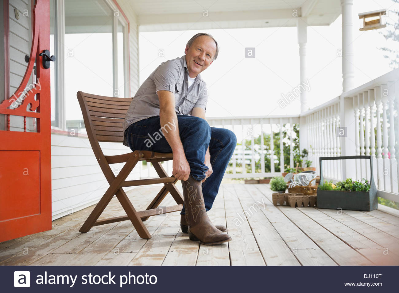 Man pulling on cowboy boots Stock Photo