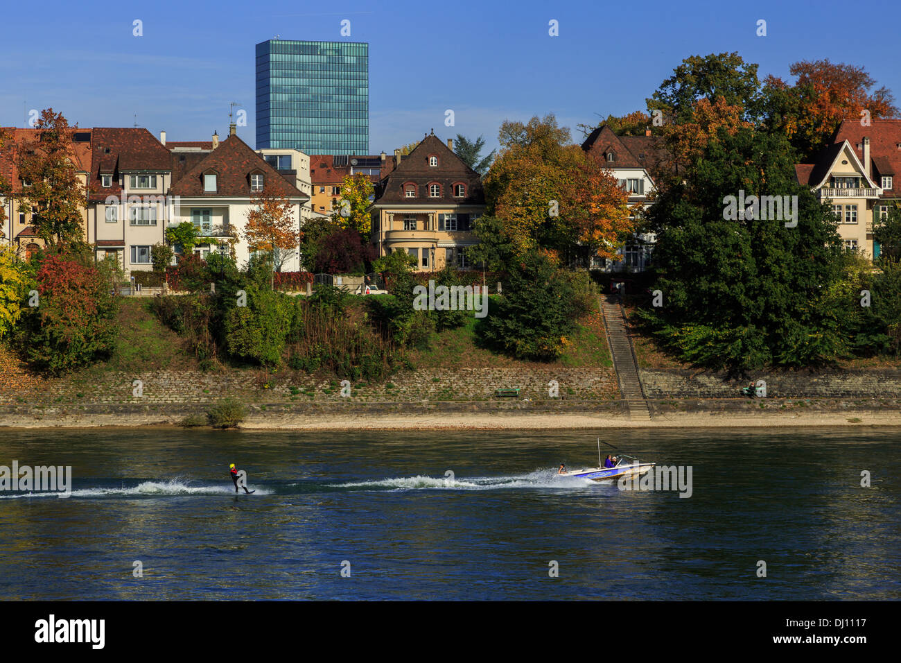A photograph of a person water skiing on the Rhine river in Switzerland. Taken at the start of autumn on a sunny day. Stock Photo