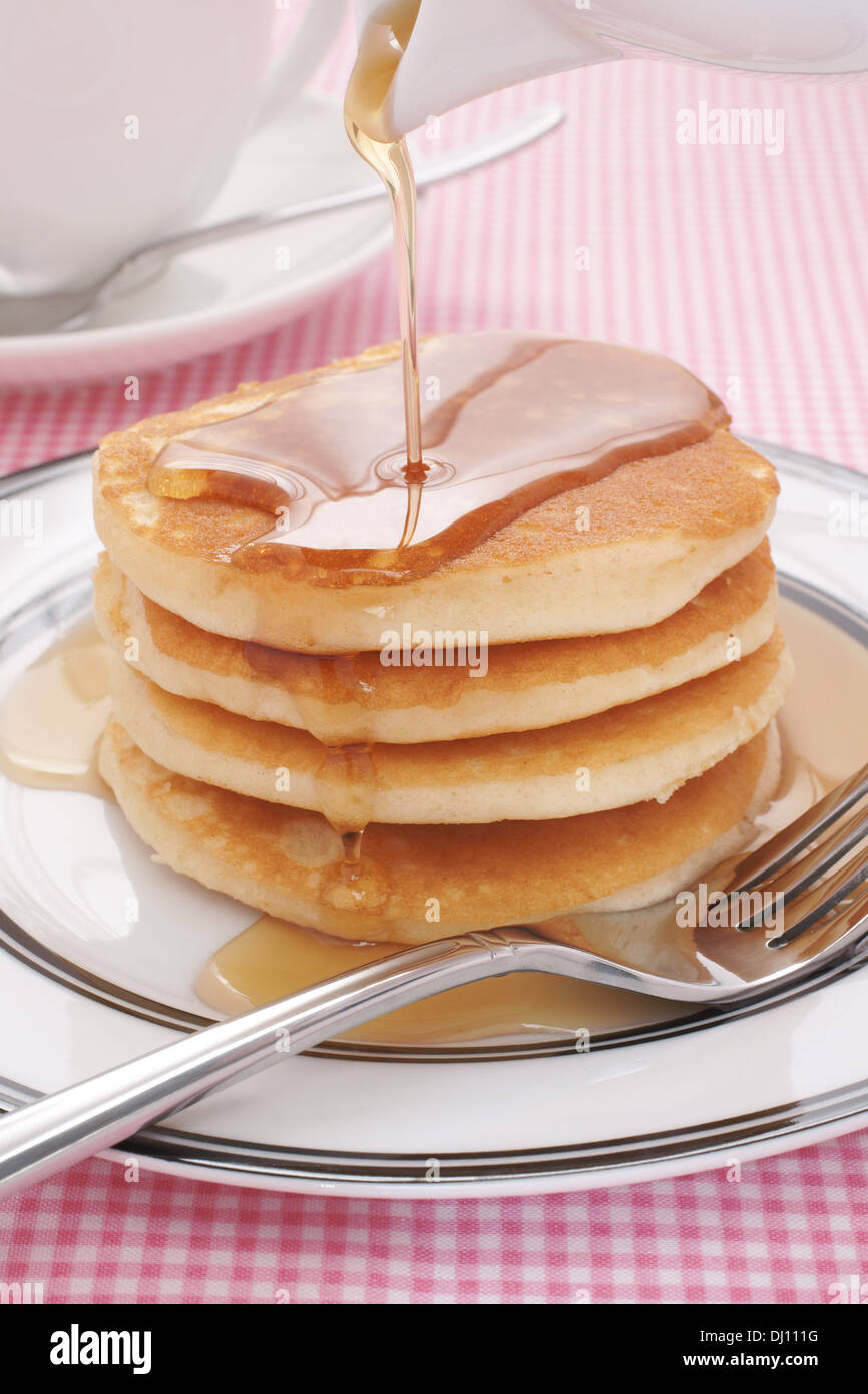 Pouring maple syrup on buttermilk pancakes Stock Photo Alamy