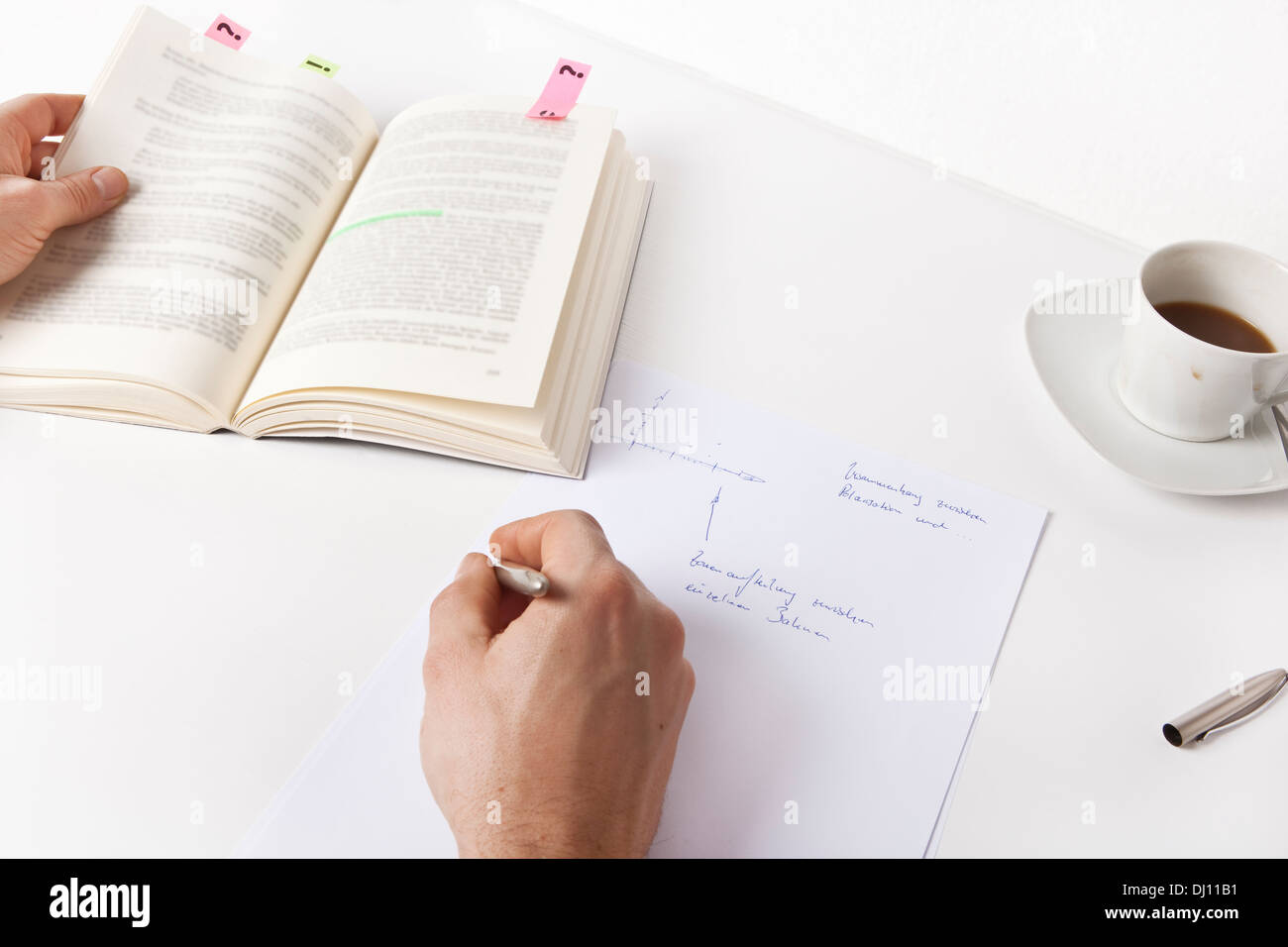Write notes from a book, only the hands are seen, no face Stock Photo