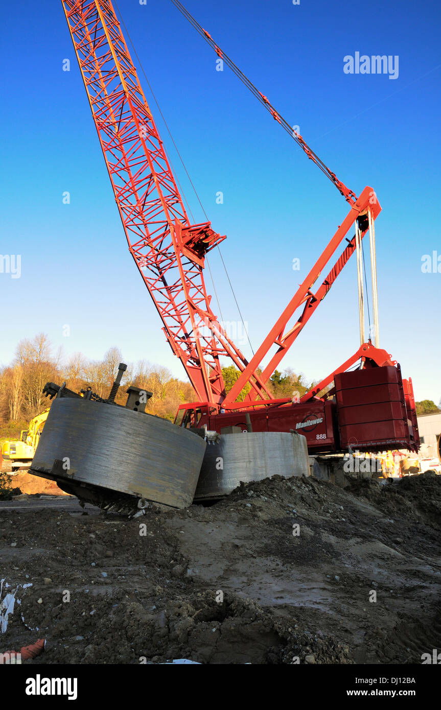 Heavy construction crane shown with dirt boring tools in the foreground