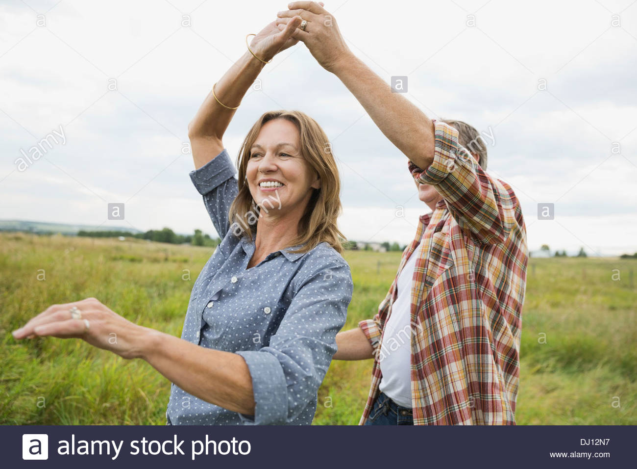Senior couple dancing in field Stock Photo