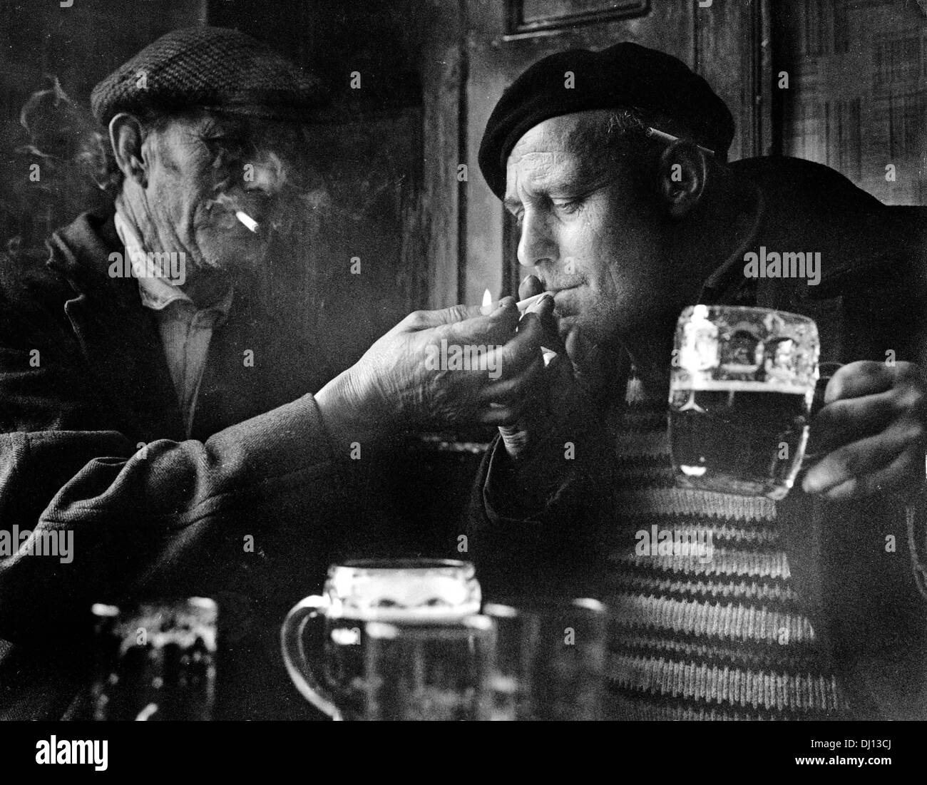 Men lighting cigarette and drinking beer in Malt Shovel pub in Tower Street, Dudley, Uk 1964 Stock Photo