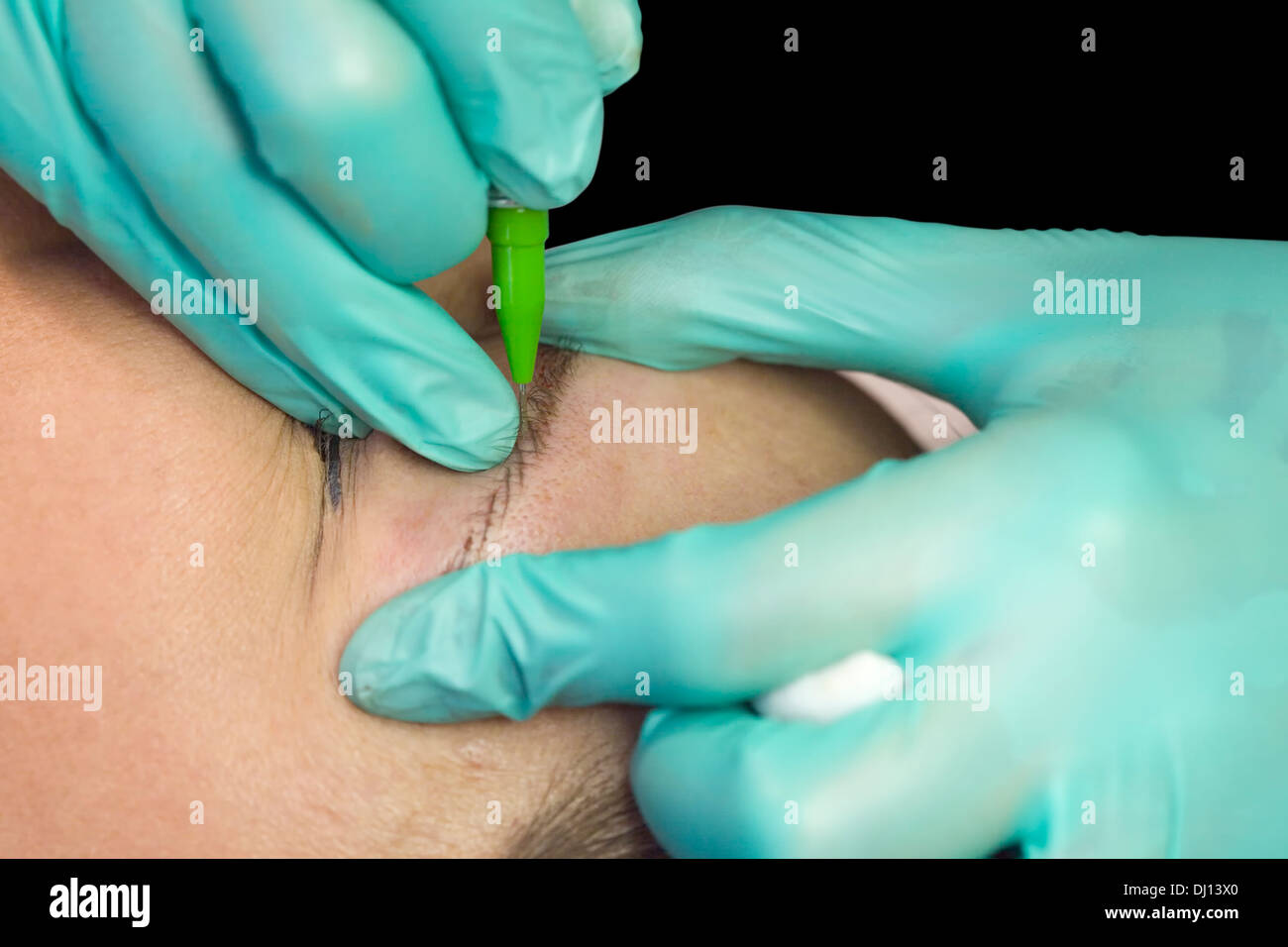 Applying Permanent Makeup on Eyebrow Stock Photo