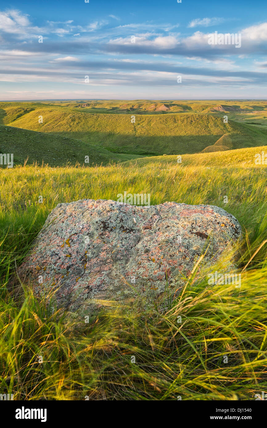 Sunset Over The Coulees And Buttes Of Grasslands National Park With Erratic In Foreground; Saskatchewan, Canada Stock Photo