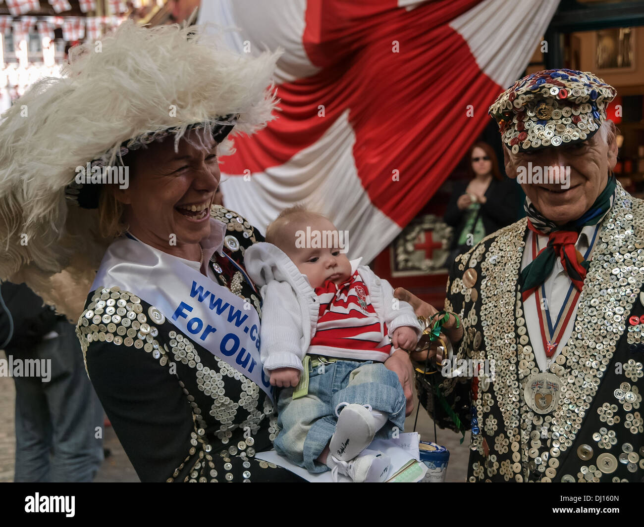 Pearly Queen & Pearly King with a baby, whilst collecting for children's charities in London. Stock Photo