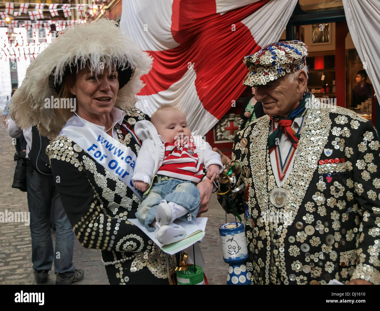 Pearly Queen & Pearly King with a baby, whilst collecting for children's charities in London. Stock Photo
