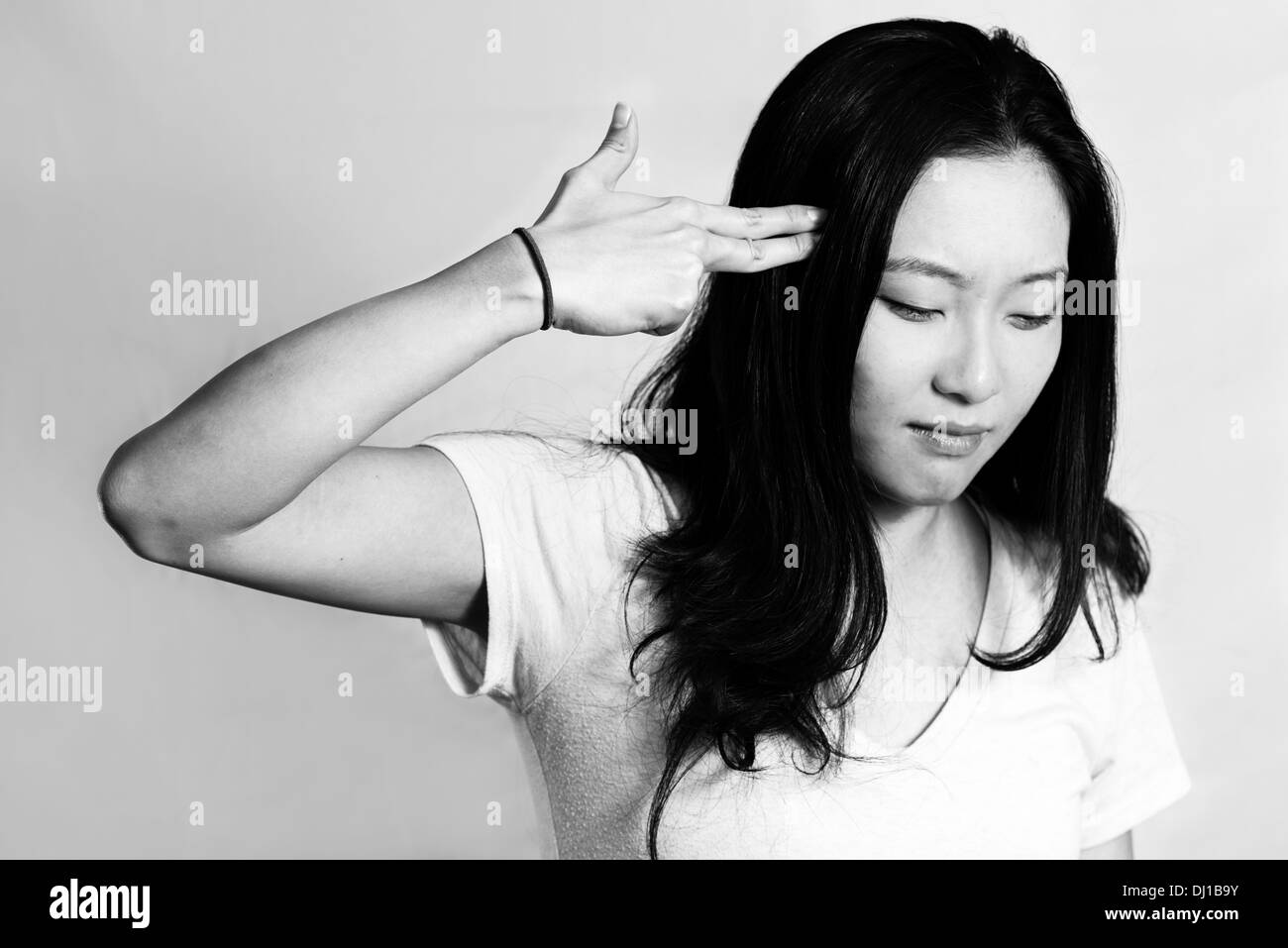 Portrait of depressed young woman hand signals suicide, black and white style Stock Photo