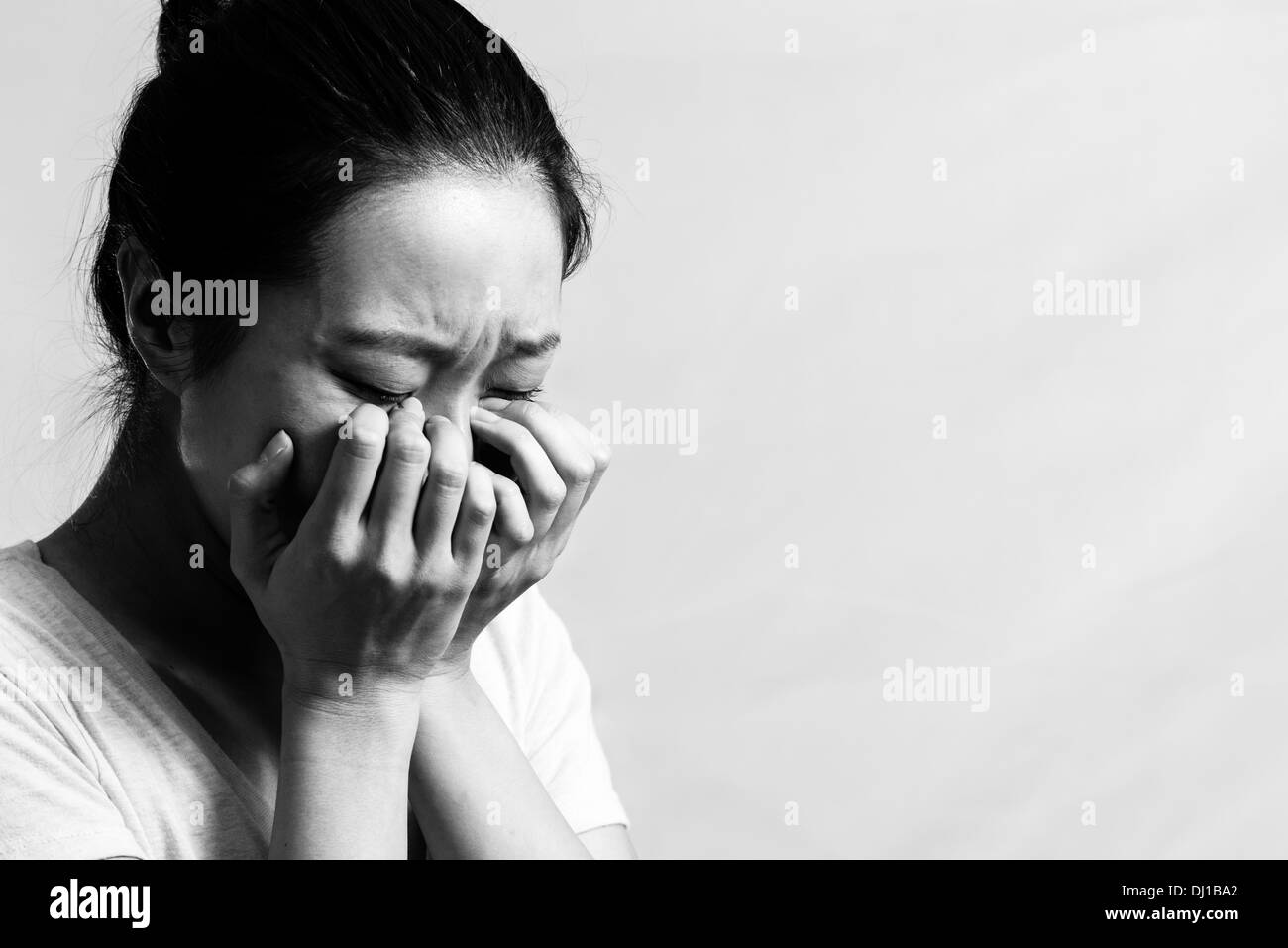 Portrait of pretty girl crying desperately, black and white style Stock Photo