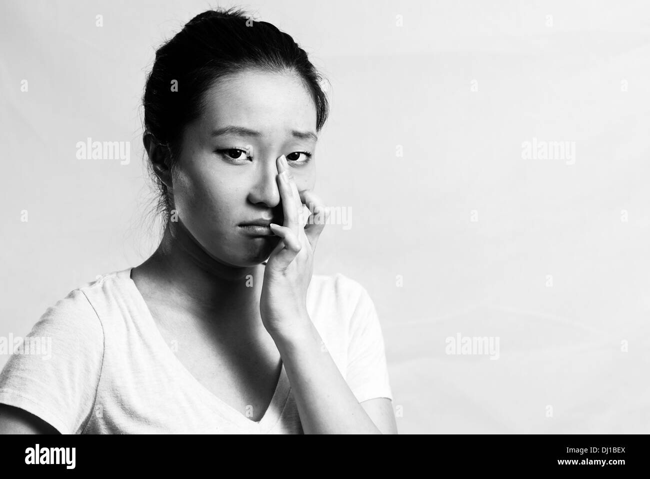 Portrait of pretty girl crying desperately, black and white style Stock Photo