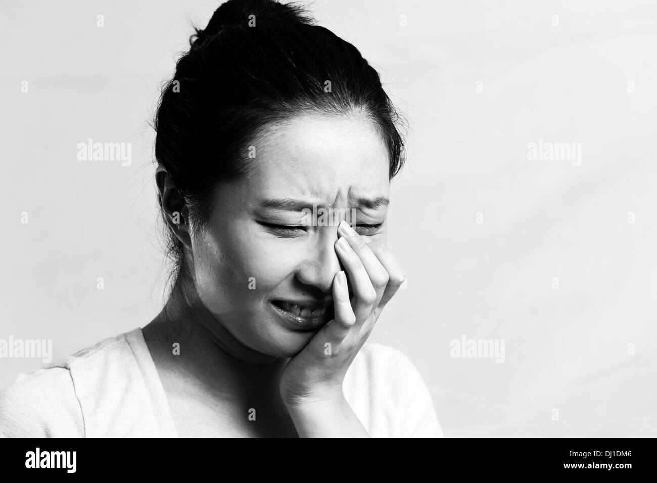 Portrait of pretty girl crying desperately, black and white style Stock Photo