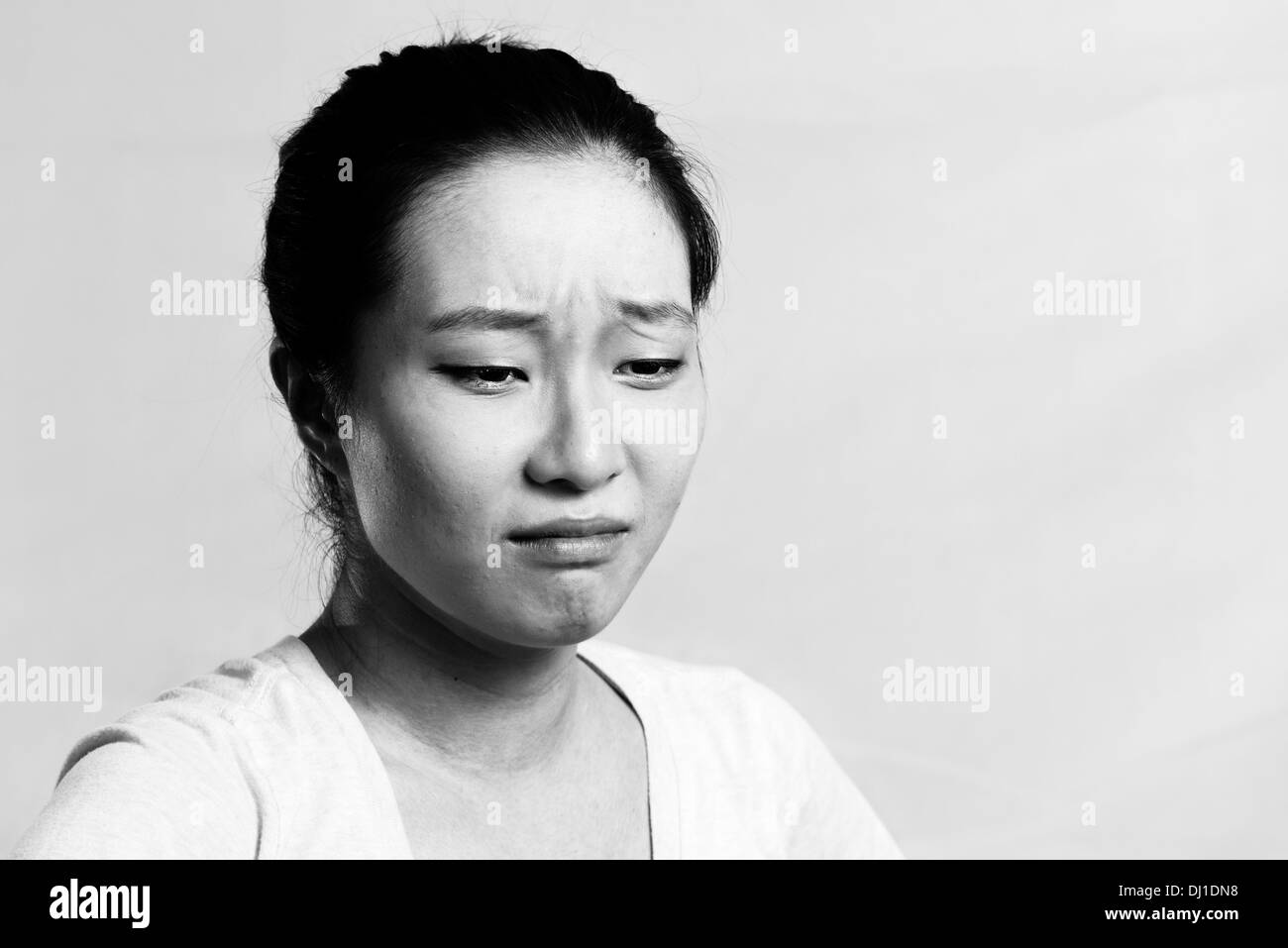 Portrait of pretty girl crying desperately, black and white style Stock Photo
