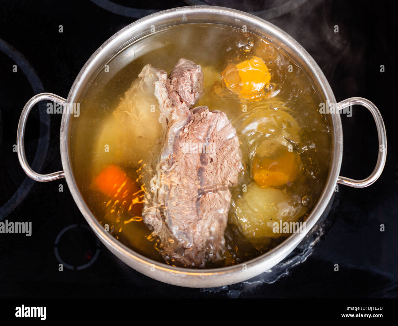 open pan with cooking beef broth with with seasoning vegetables Stock Photo