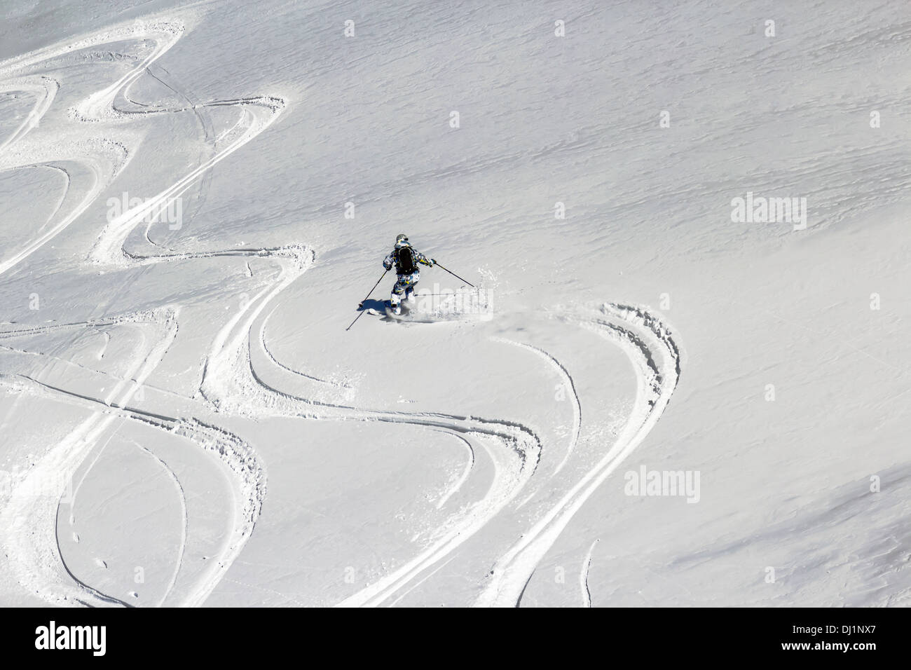 Ski trails cutting through Thin crust of ice over the snow in the spring in the mountains Stock Photo