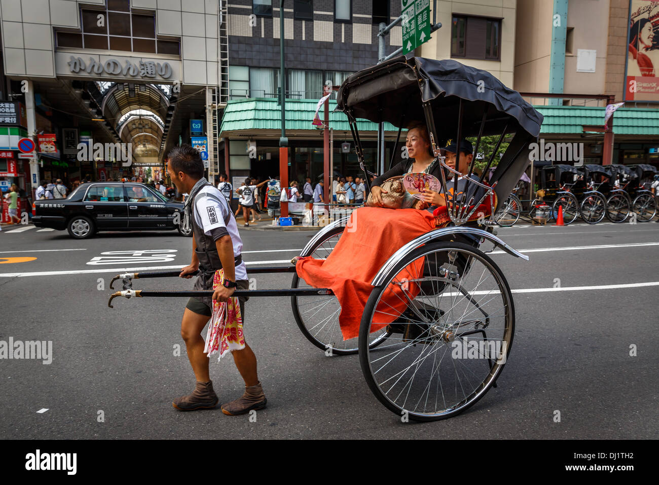 Pulled rickshaw with a passenger, Asakusa district, Taitō, Tokyo, Japan Stock Photo