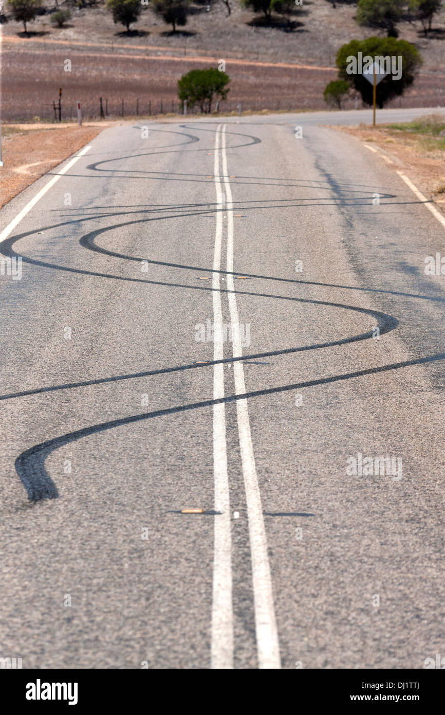 Burn out car tyre marks on road from spiinning car wheels, Murchison Western Australia Stock Photo