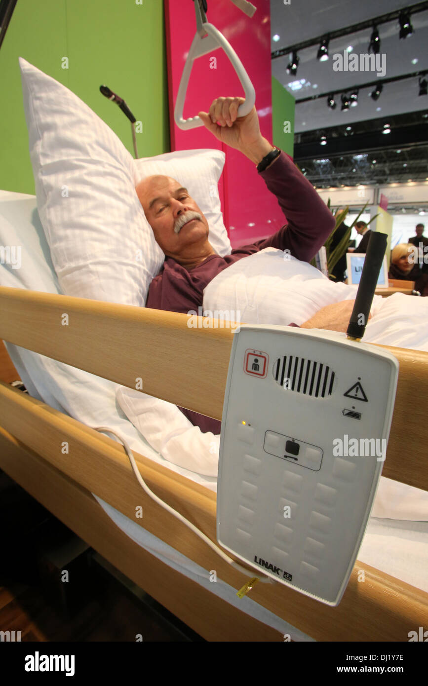 Duesseldorf, Germany. 19th Nov, 2013. A model lies in a linked up nursing bed in Duesseldorf, Germany, 19 November 2013. Sensors in the bed react when a care recipient is about to get out of bed. Lights are turned on while a signal is sent out to the control room of the nursing unit. About 4600 exhibitors present their novelties at the Medica World Forum for Medicine between 20 November 2013 and 13 November 2013. Photo: ROLAND WEIHRAUCH/dpa/Alamy Live News Stock Photo