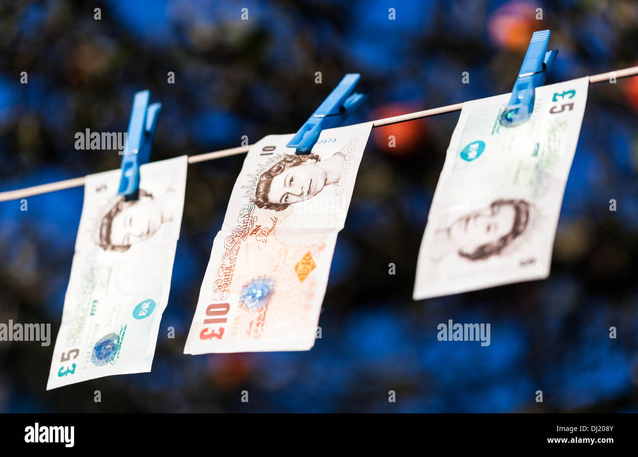 Pound sterling banknotes hanging on washing line. Stock Photo