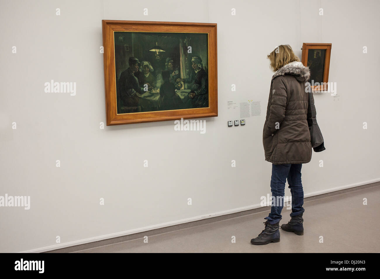Woman looking at painting The potatoe eaters by Vincent van Gogh in museum Stock Photo