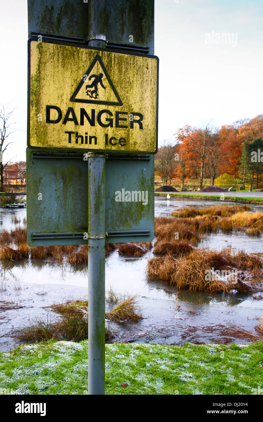 Kilsyth, Glasgow, UK. 19th November 2013. Heavy frost dusts the grass with autumn colours in the background.  Colzium Park Kilsyth. First thin icing of the pond. Credit:  ALAN OLIVER/Alamy Live News Stock Photo