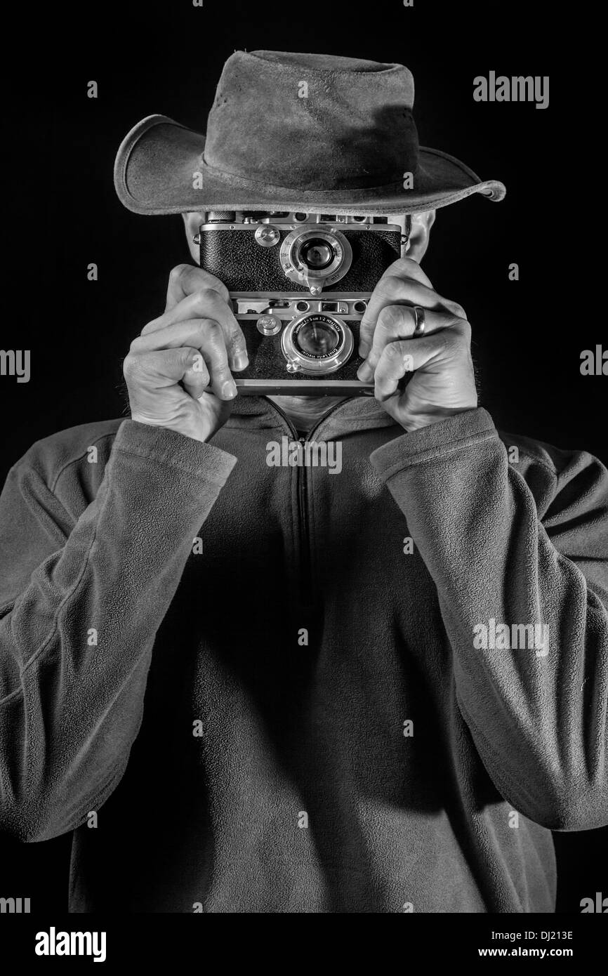 A man holding two vintage cameras. Stock Photo