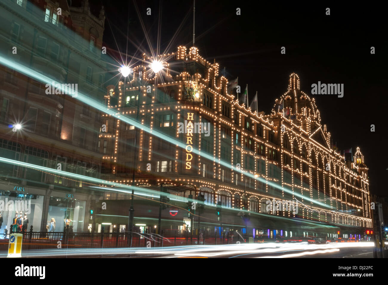 Harrod's department store behind light trails from double decker London bus Stock Photo