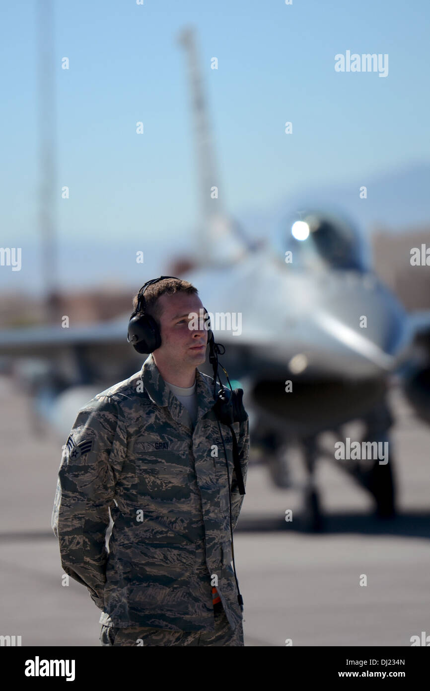 U.S. Air Force Senior Airman Casey Gray, a crew chief with the 169th Aircraft Maintenance Squadron at McEntire Joint National Guard Base, South Carolina Air National Guard, waits to marshal an F-16 Fighting Falcon fighter jet preparing to taxi and takeoff Stock Photo