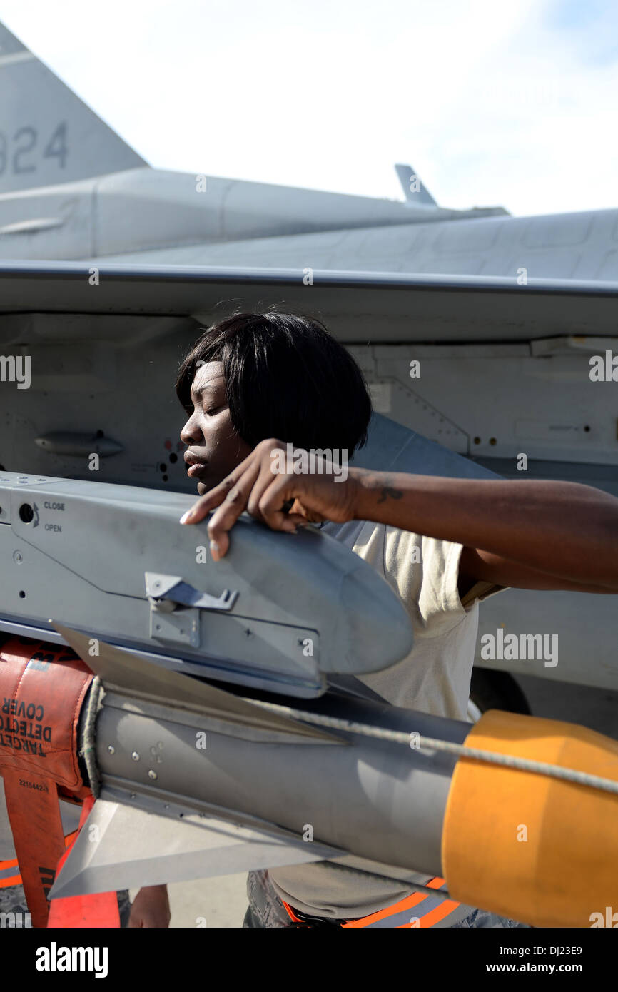 U.S. Air Force Senior Airman Brittany Davis, a weapons loader with the 169th Aircraft Maintenance Squadron at McEntire Joint National Guard Base, South Carolina Air National Guard, loads a missile onto the wing of an F-16 Fighting Falcon fighter jet at Ne Stock Photo