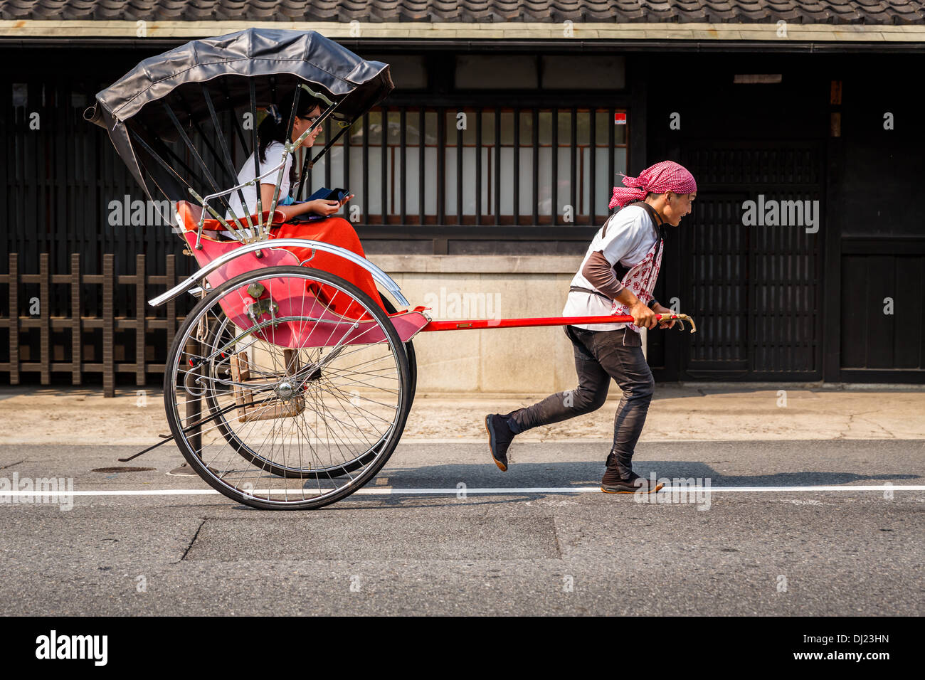 A pulled rickshaw with passenger, Arashiyama, Kyoto, Japan Stock Photo