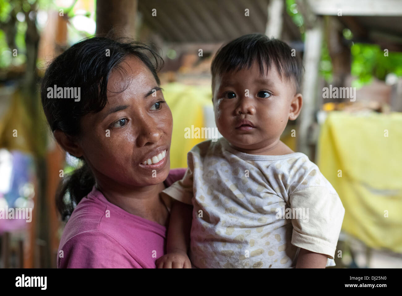 Mother child poor Bali poverty challenged extreme hold feed poor bellow standard Indonesia 29 house conditions harsh filthy Stock Photo