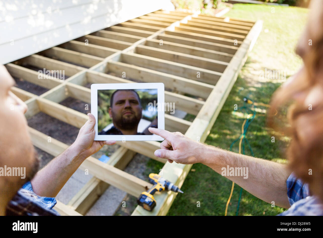 Carpenters Using Digital Tablet At Construction Site Stock Photo