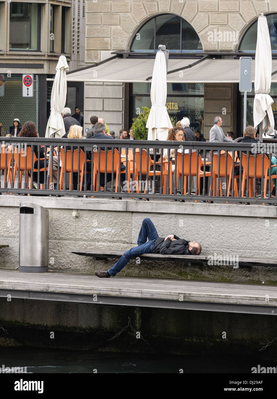 Zurich, Switzerland: A person resting on the river shore Stock Photo
