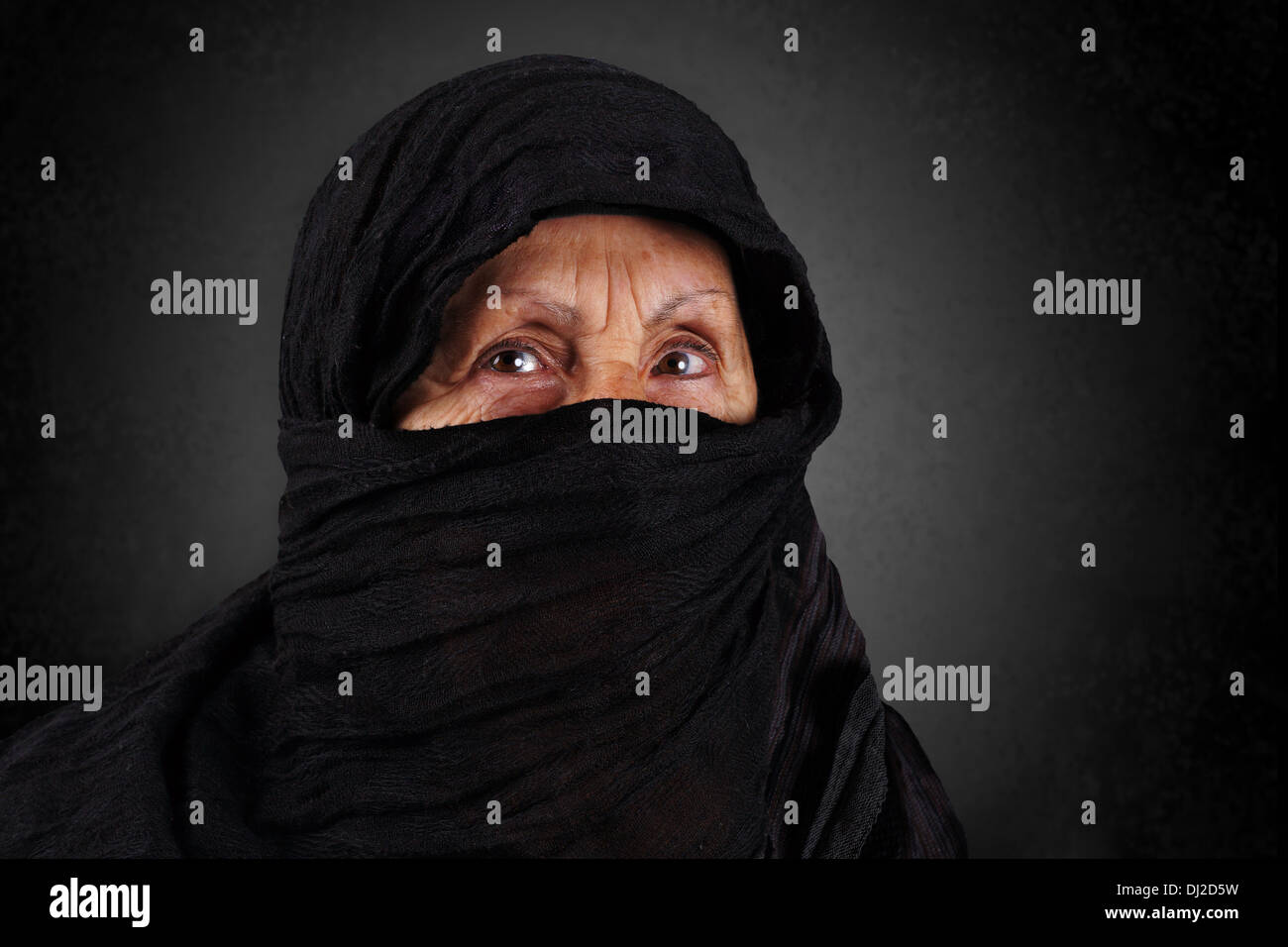 Dramatic portrait of senior muslim woman with niqab and hijab Stock Photo