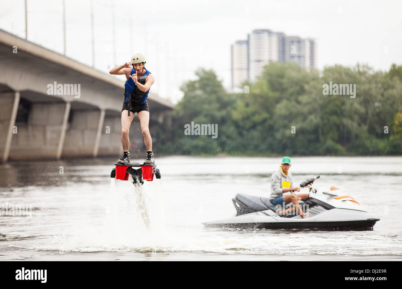 Young man on flyboard pretending taking picture, humorous aspect Stock Photo