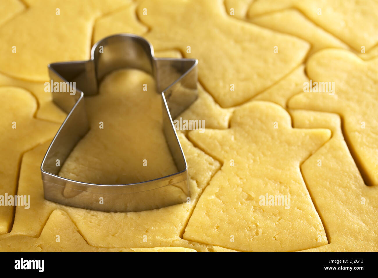 Cutting out Christmas cookies from shortcrust dough with an angel shaped cutter (Selective Focus) Stock Photo