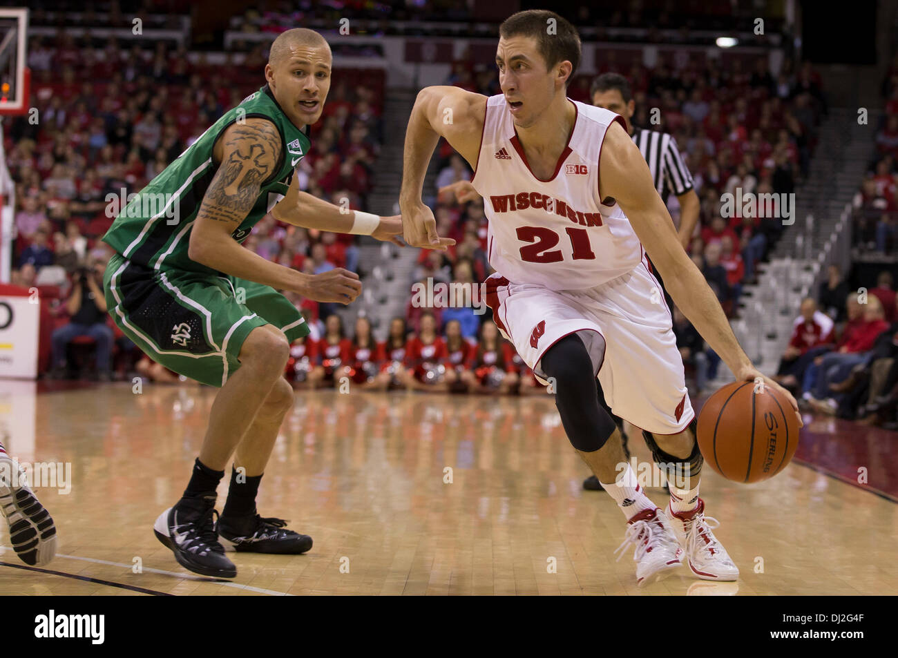 Madison, Wisconsin, USA. 19th Nov, 2013. November 19, 2013: Wisconsin Badgers guard Josh Gasser #21 dribbles past North Dakota Fighting Sioux guard/forward Troy Huff #5 on the way to the basket during the NCAA Basketball game between the North Dakota Fighting Sioux and the Wisconsin Badgers at the Kohl Center in Madison, WI. Wisconsin defeated North Dakota 103-85. John Fisher/CSM/Alamy Live News Stock Photo
