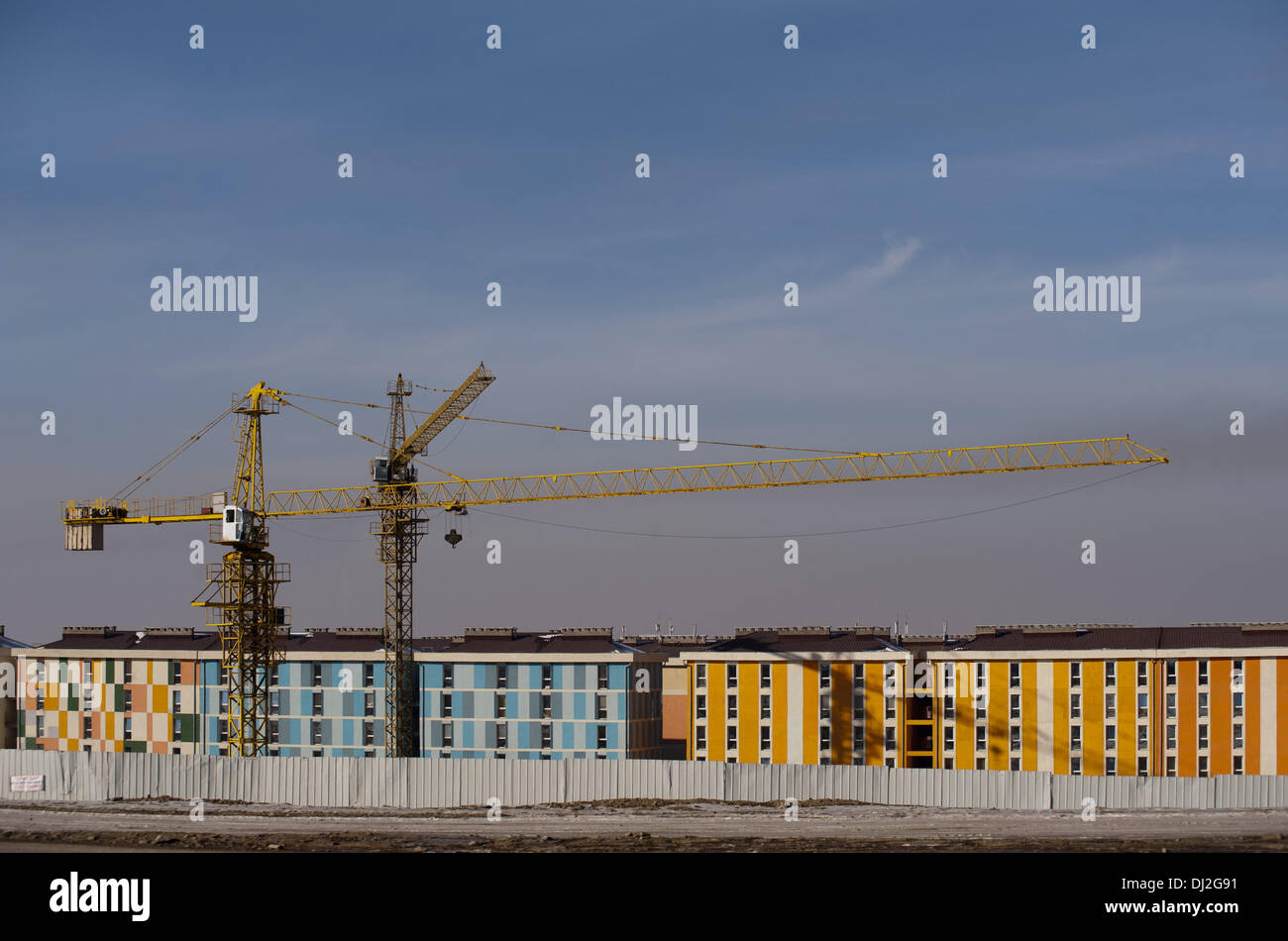 A crane lifts construction materials at a new real estate housing