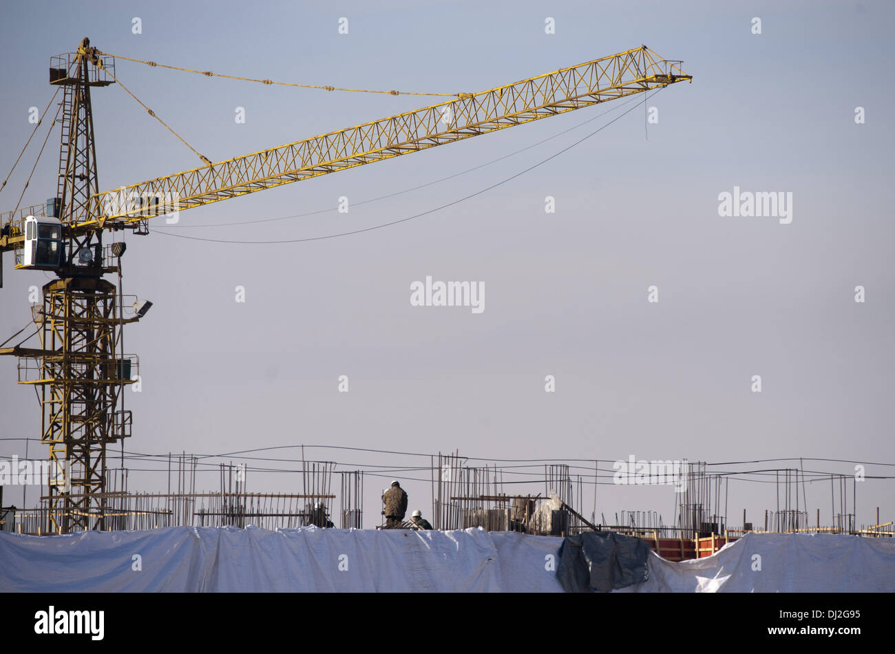A crane lifts construction materials at a new real estate housing