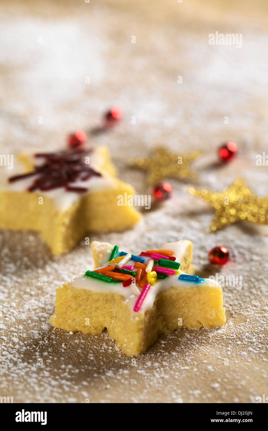 Star-shaped cookie with colorful sprinkles on top (Selective Focus, Focus on the two horizontal star arms in the front) Stock Photo