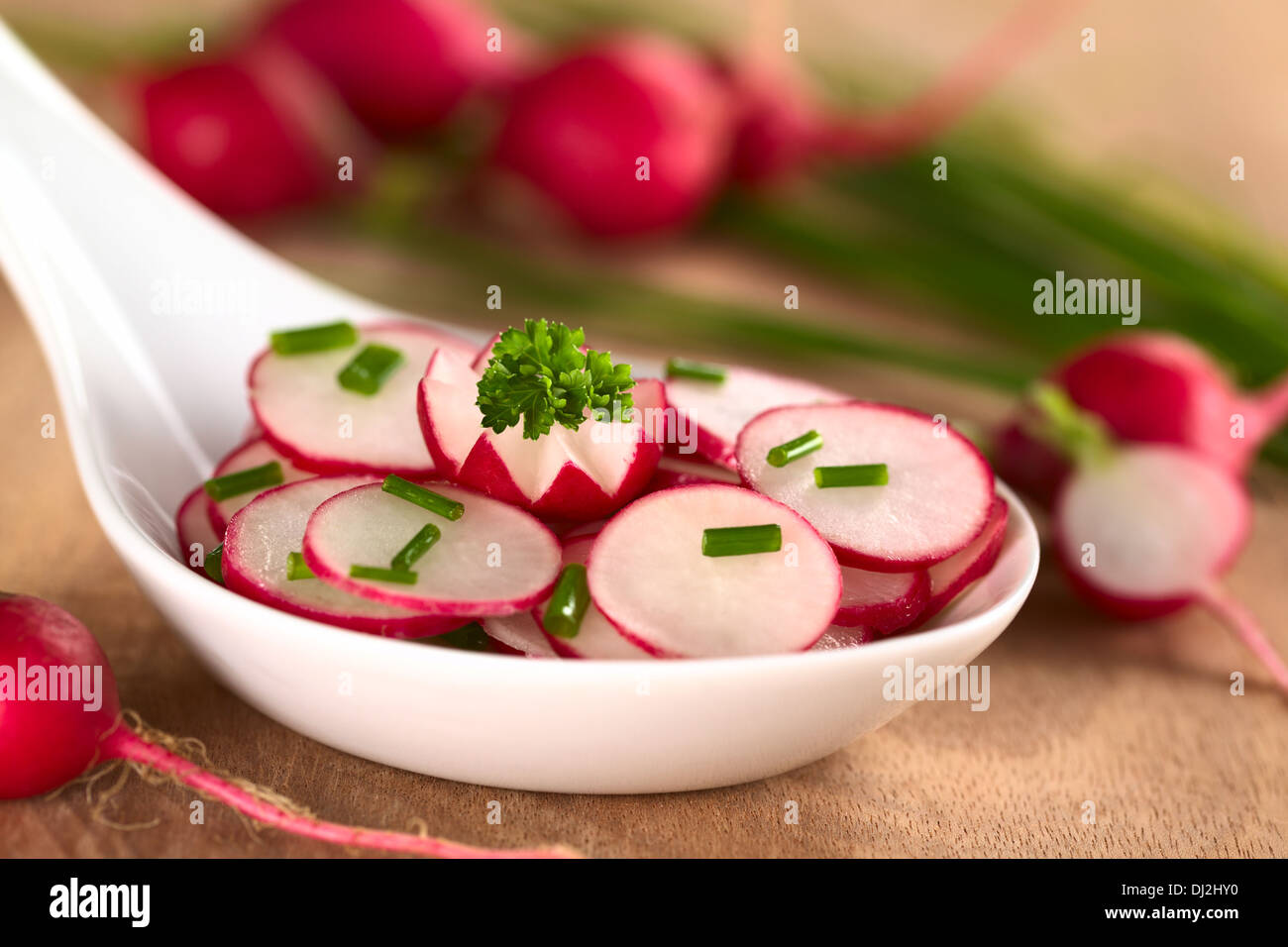 Fresh radish salad with chives (Selective Focus, Focus on the front of the parsley leaf and the radish garnish below) Stock Photo