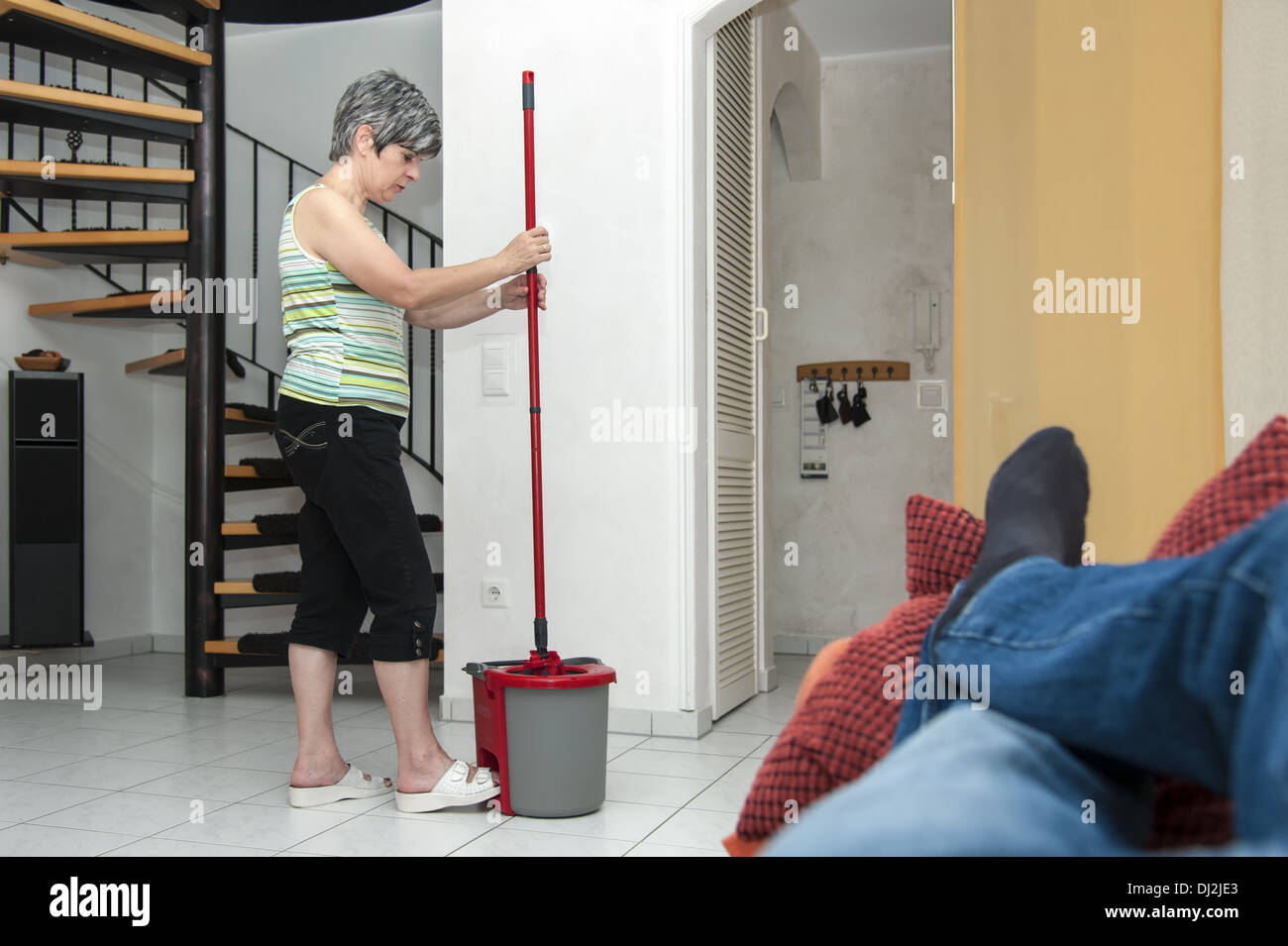 Woman with mop bucket in the living room Stock Photo